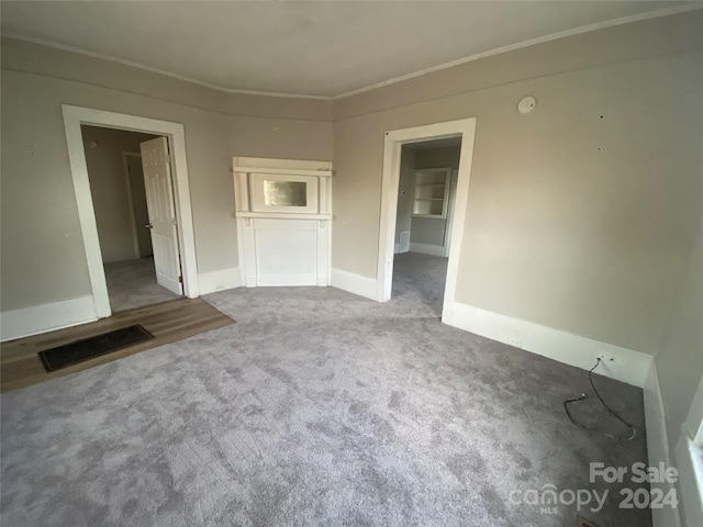 empty room with carpet flooring and crown molding