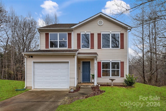 view of property with a garage and a front yard