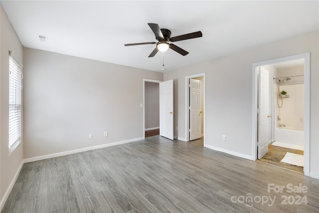 unfurnished bedroom featuring ensuite bath, ceiling fan, and wood-type flooring