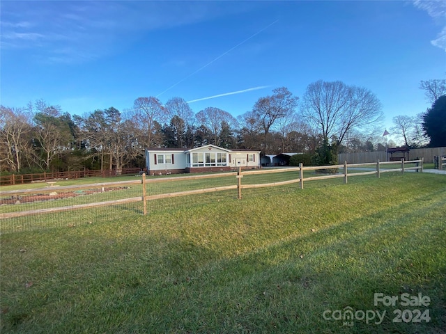 view of front of house with a rural view and a front yard