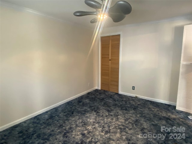 carpeted spare room featuring ceiling fan and ornamental molding