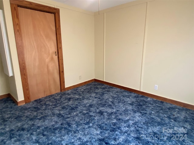 unfurnished bedroom featuring dark carpet