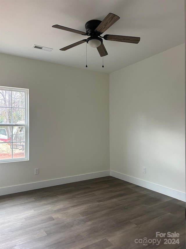 empty room with ceiling fan and dark wood-type flooring