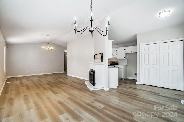 kitchen with a notable chandelier, white cabinets, lofted ceiling, and light wood-type flooring