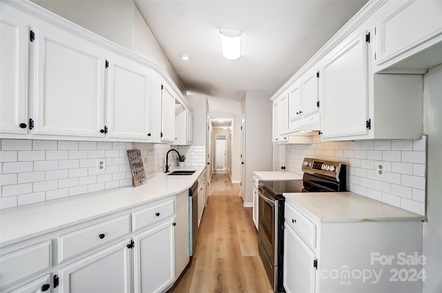 kitchen featuring decorative backsplash, white cabinetry, and appliances with stainless steel finishes