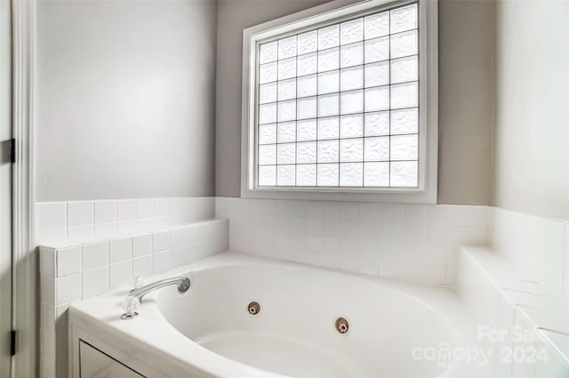 bathroom featuring a bathing tub and a wealth of natural light