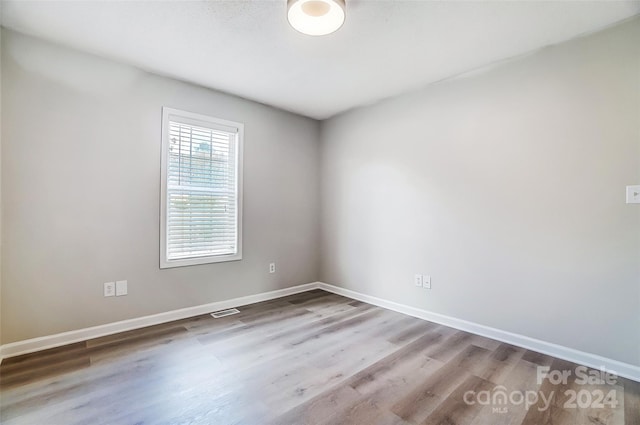 unfurnished room with hardwood / wood-style flooring