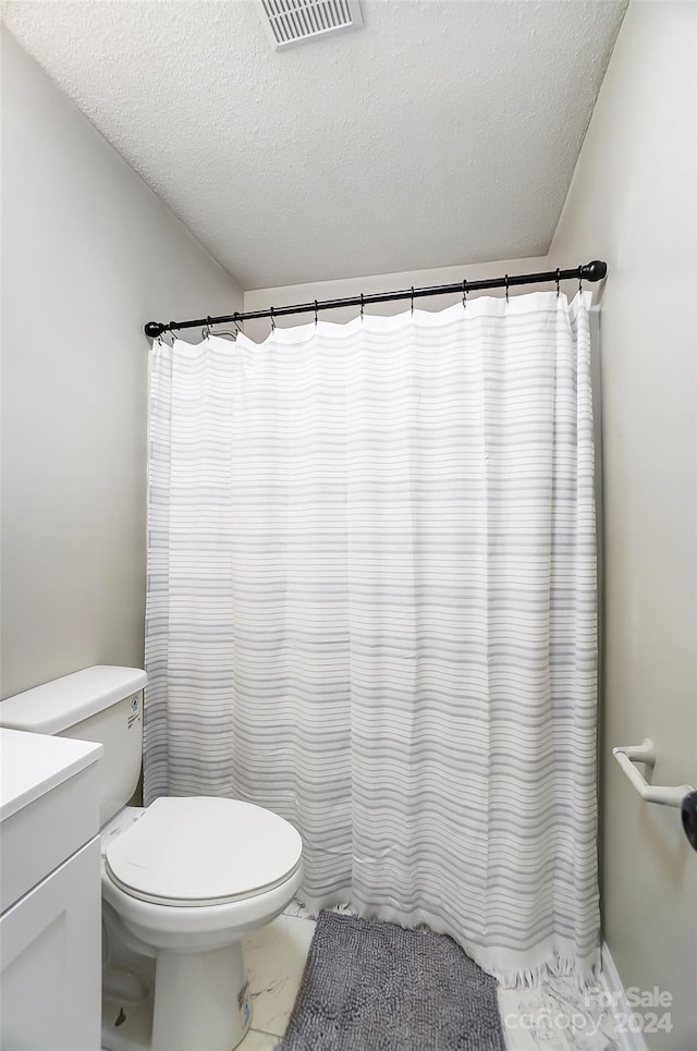 bathroom featuring vanity, toilet, and a textured ceiling