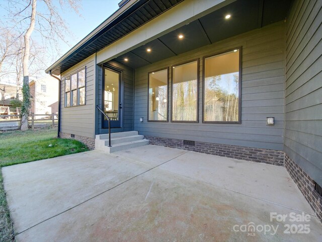 view of front facade with a patio and crawl space