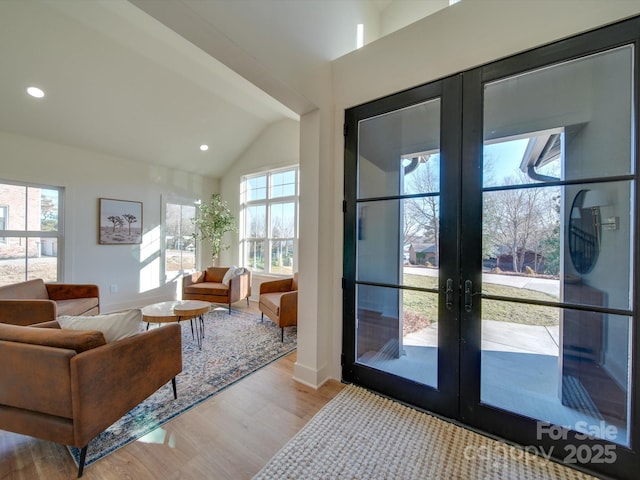 doorway to outside with lofted ceiling, french doors, a healthy amount of sunlight, and light wood-type flooring