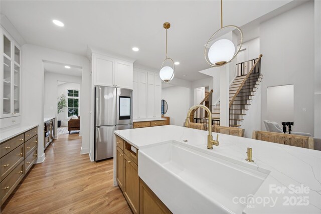 kitchen with glass insert cabinets, light wood-type flooring, smart refrigerator, white cabinetry, and a sink