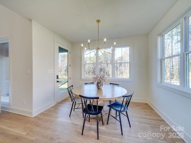 dining area with a notable chandelier and light hardwood / wood-style flooring