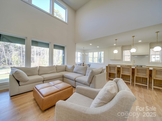 living room with sink, light hardwood / wood-style flooring, and plenty of natural light