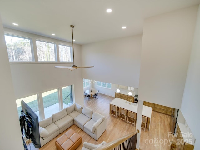 living room featuring a ceiling fan, recessed lighting, and wood finished floors