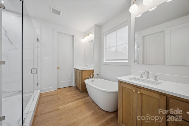 bathroom with vanity, separate shower and tub, and wood-type flooring