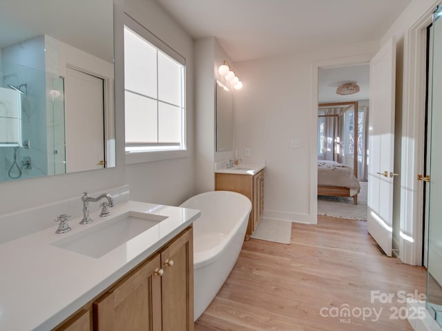 bathroom with a stall shower, wood finished floors, and a sink