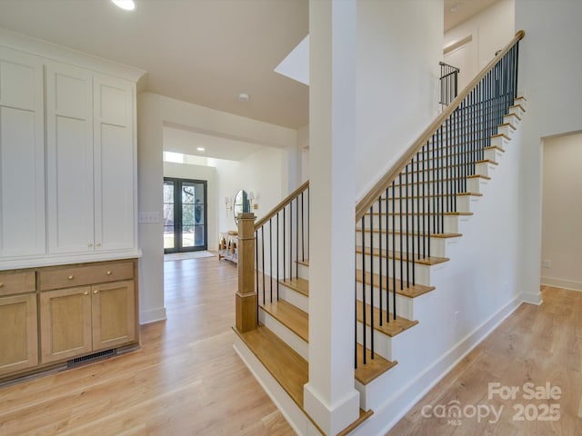 stairway featuring recessed lighting, french doors, baseboards, and wood finished floors