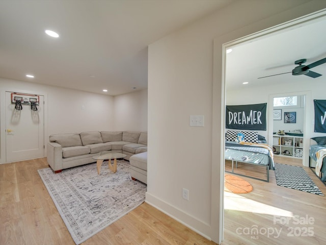 living room with a ceiling fan, recessed lighting, and wood finished floors