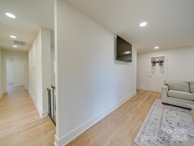 hallway with recessed lighting, visible vents, baseboards, and light wood finished floors