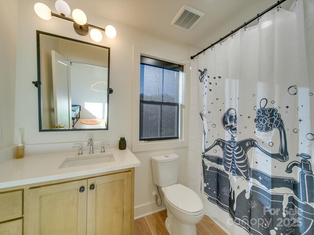 full bath with vanity, a shower with shower curtain, wood finished floors, visible vents, and toilet