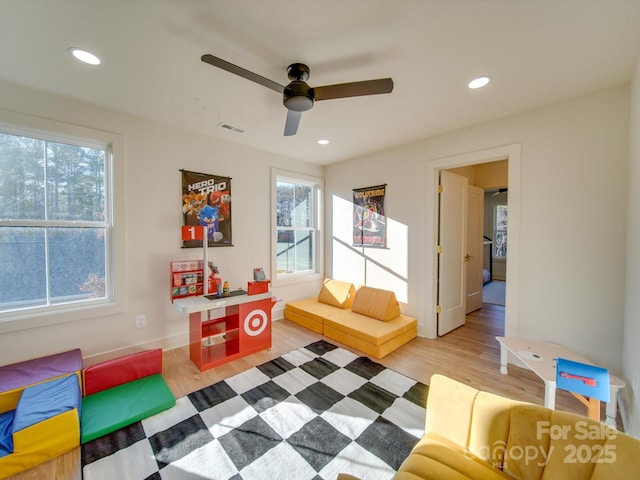 playroom with hardwood / wood-style floors, a wealth of natural light, and ceiling fan