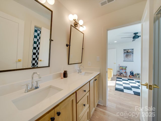 bathroom featuring ceiling fan, vanity, and wood-type flooring