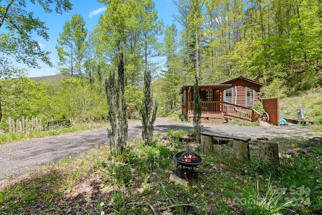 view of yard with an outdoor fire pit and a wooden deck