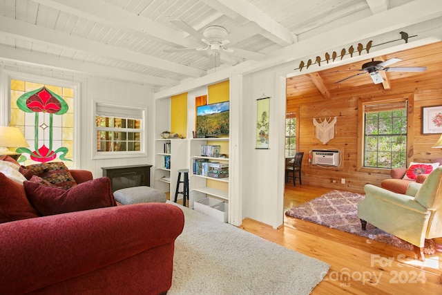 living room with beam ceiling, hardwood / wood-style flooring, ceiling fan, and wood walls