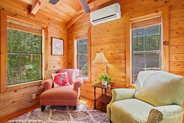 living area featuring a wall mounted air conditioner and a wealth of natural light