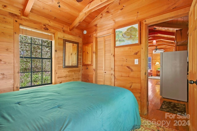 bedroom with vaulted ceiling with beams, wood walls, wood-type flooring, and wooden ceiling