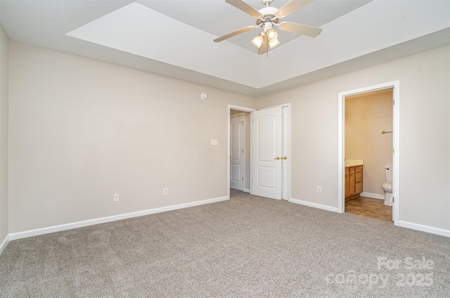 unfurnished bedroom featuring ceiling fan, carpet floors, and ensuite bath