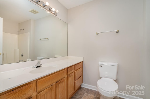 bathroom featuring vanity, toilet, and walk in shower