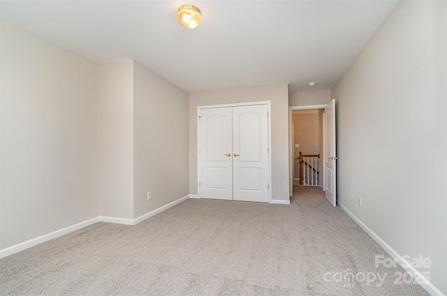 unfurnished bedroom featuring a closet and light colored carpet