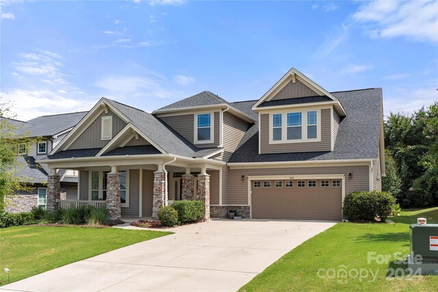 craftsman-style home with a front yard, a porch, and a garage