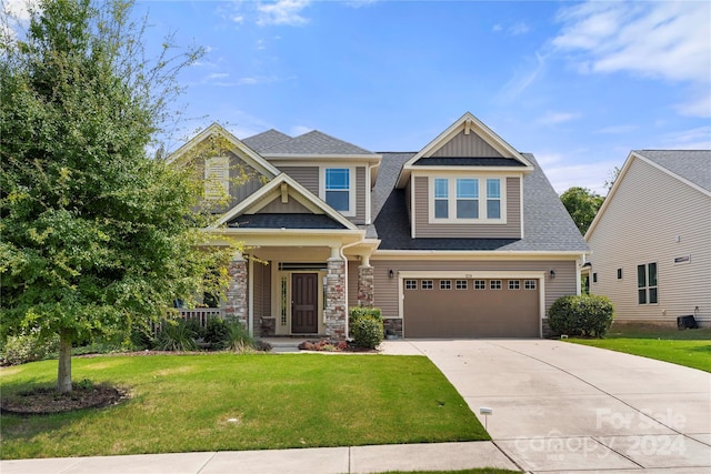 craftsman inspired home featuring covered porch, a garage, and a front lawn