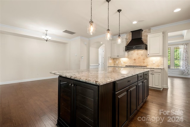 kitchen with dark hardwood / wood-style floors, a kitchen island, and custom range hood