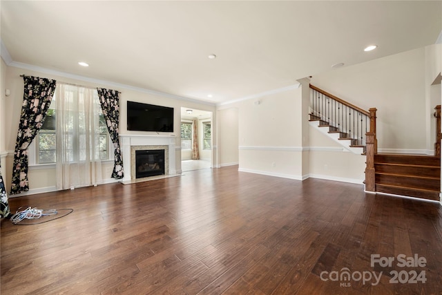 unfurnished living room featuring dark hardwood / wood-style floors, plenty of natural light, and crown molding