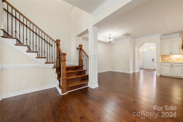 interior space with hardwood / wood-style flooring, ornamental molding, and a notable chandelier