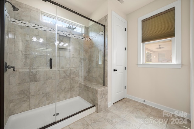 bathroom featuring a shower with door and a healthy amount of sunlight