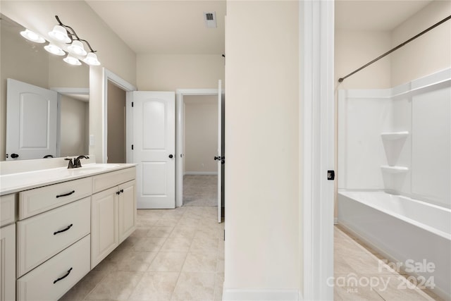 bathroom featuring tile patterned flooring, vanity, and washtub / shower combination