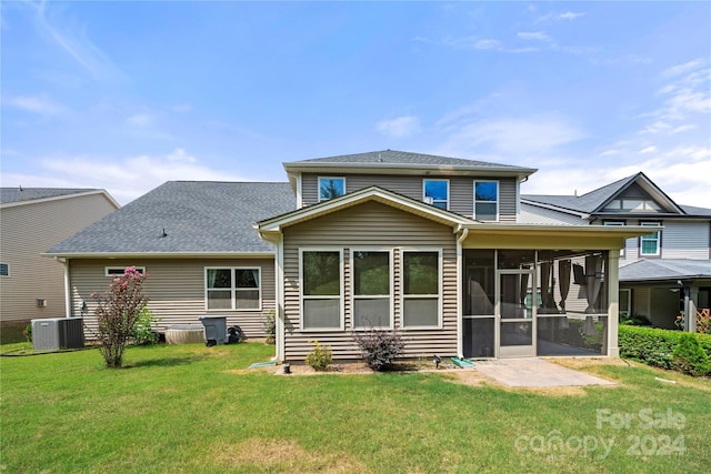 rear view of property featuring central AC unit, a lawn, and a sunroom