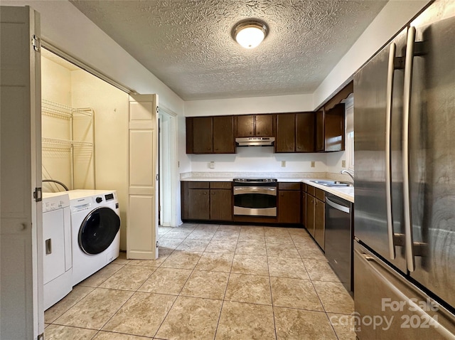 kitchen with washing machine and clothes dryer, dark brown cabinets, stainless steel appliances, and a textured ceiling