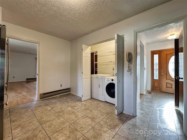 laundry room with light wood-type flooring, independent washer and dryer, a textured ceiling, and a baseboard radiator