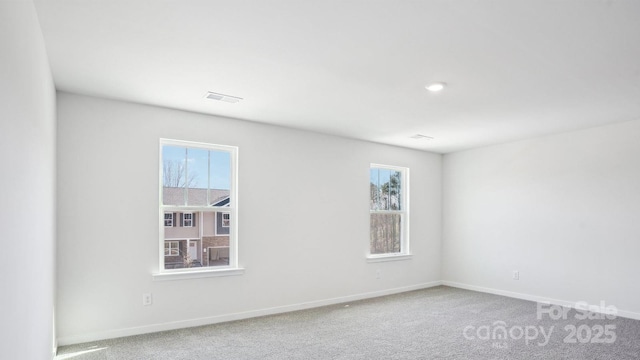 unfurnished room with carpet flooring, visible vents, and baseboards