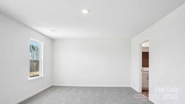 empty room featuring baseboards and carpet flooring