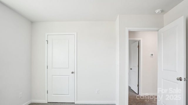 unfurnished bedroom with carpet floors and baseboards