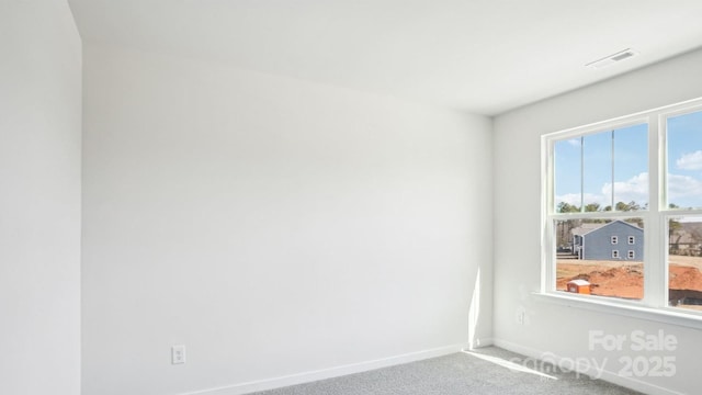 unfurnished room featuring carpet floors, visible vents, and baseboards