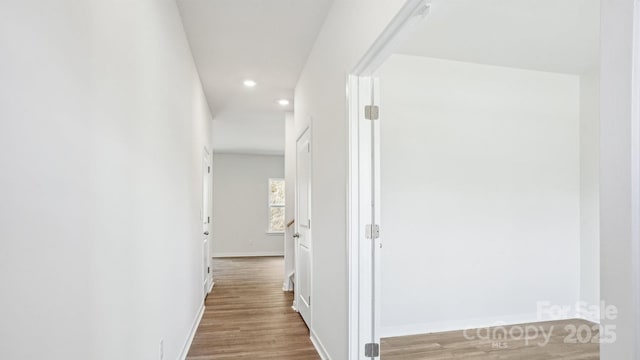 corridor featuring recessed lighting, baseboards, and wood finished floors