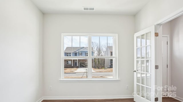 unfurnished room with baseboards and visible vents