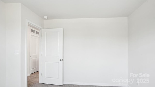 spare room with light carpet, baseboards, and visible vents